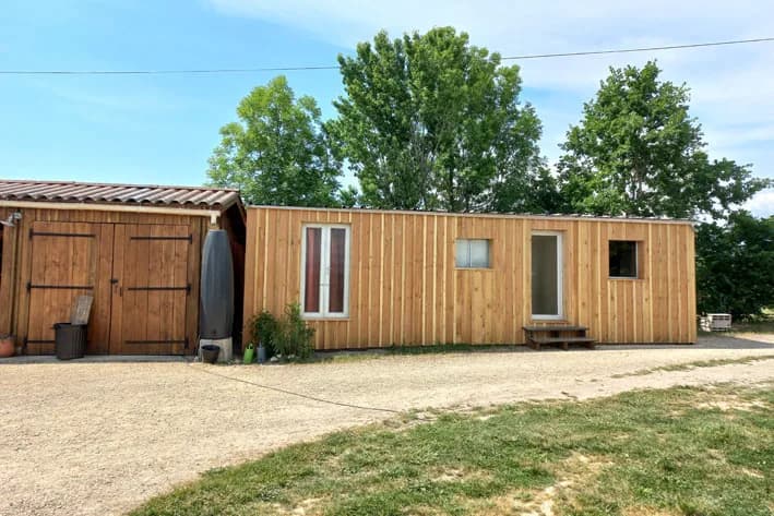 Annexe fermée et bardée de bois, avec fenêtres et porte vitrée